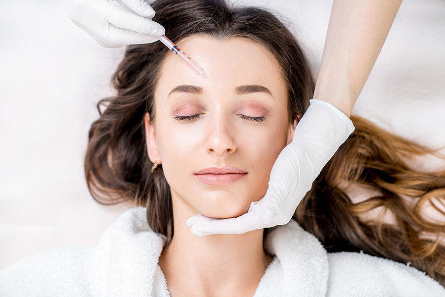 Woman receiving cosmetic injection in her forehead