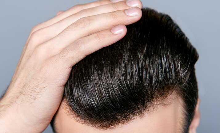 Close up photo of man combing his hair with fingers