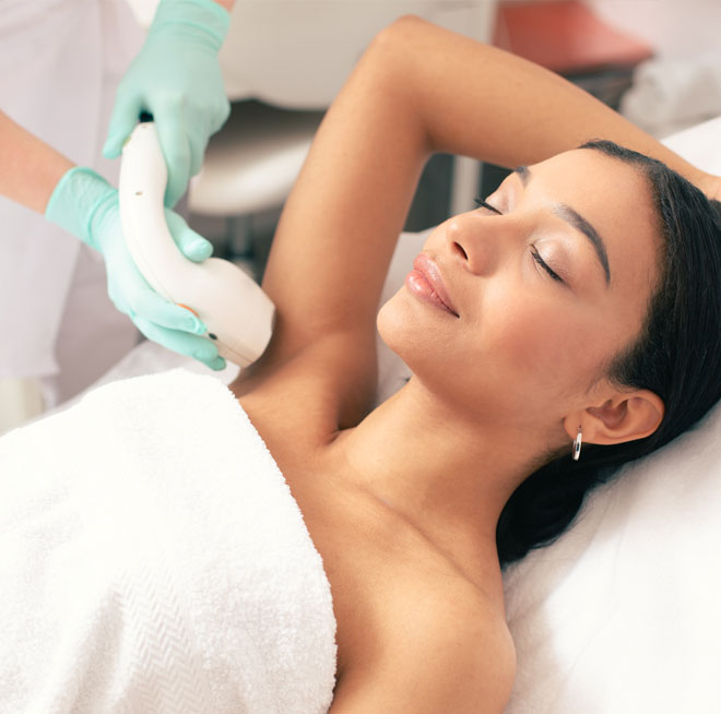 Smiling woman undergoing laser hair removal on her armpit